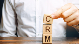 Wooden blocks with the word CRM (Customer Relationship Management) and businessman