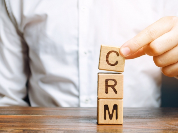 Wooden blocks with the word CRM (Customer Relationship Management) and businessman